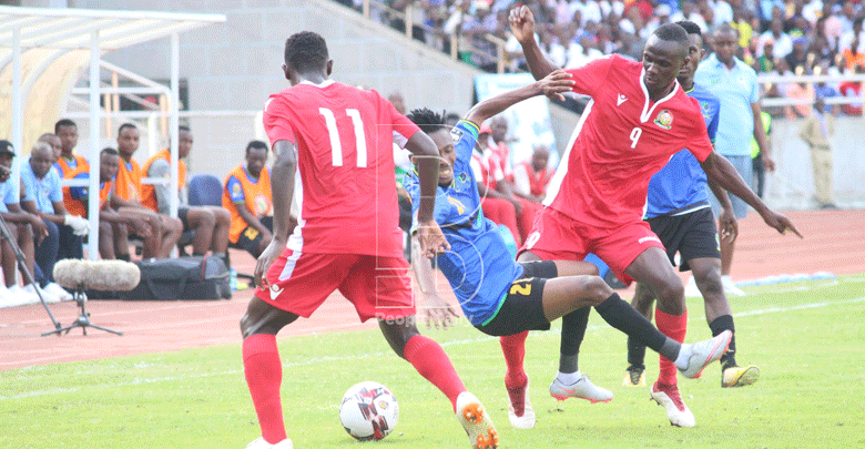 Kenya's Duke Abuya (L) and Enosh Ochieng (R) challenges for the ball with a Tanzania opponent during their CHAN qualifier in Dar es Salaam on Sunday. Photo/David Ndolo