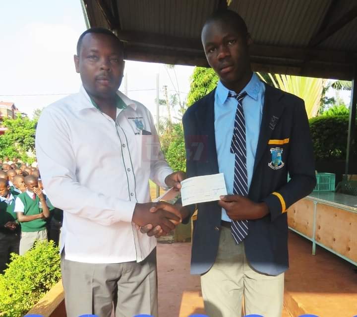 Murang'a High School Deputy Principal (academics) Charles Karanja presents a Sh50,000 post-dated cheque to Simiyu Robinson Wanjala ahead of the 2020 KCSE exams, which was to be his reward if he emerged the best candidate. PHOTO: COURTESY