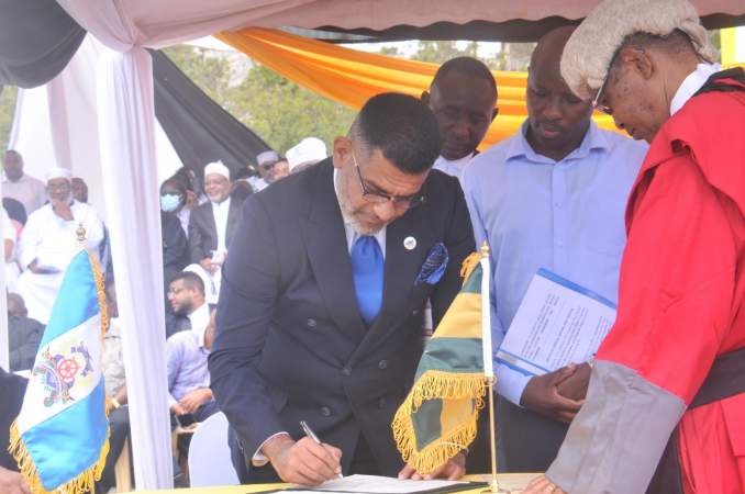 EACC Head of Corporate Affairs & Communication Eric Ngumbi and High Court Judge George Dulu witness the signing of integrity oath by Mombasa Governor.