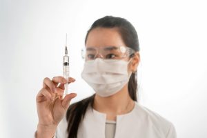 Woman Wearing a Face Mask Holding a Syringe. PHOTO/Pexels