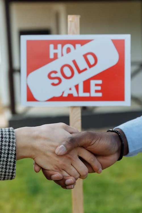 Visual representation of people shaking hands after completing land transaction. PHOTO/Pexels