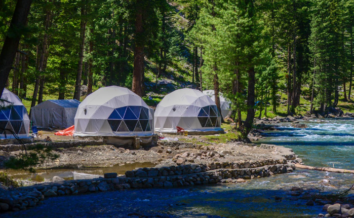 Geodesic tents on the side of a river. PHOTO/Pexels