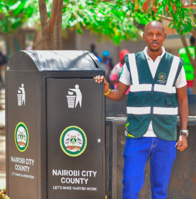 Geoffrey Mosiria standing beside the newly-installed dustbin in CBD. PHOTO/@HonMosiria/X
