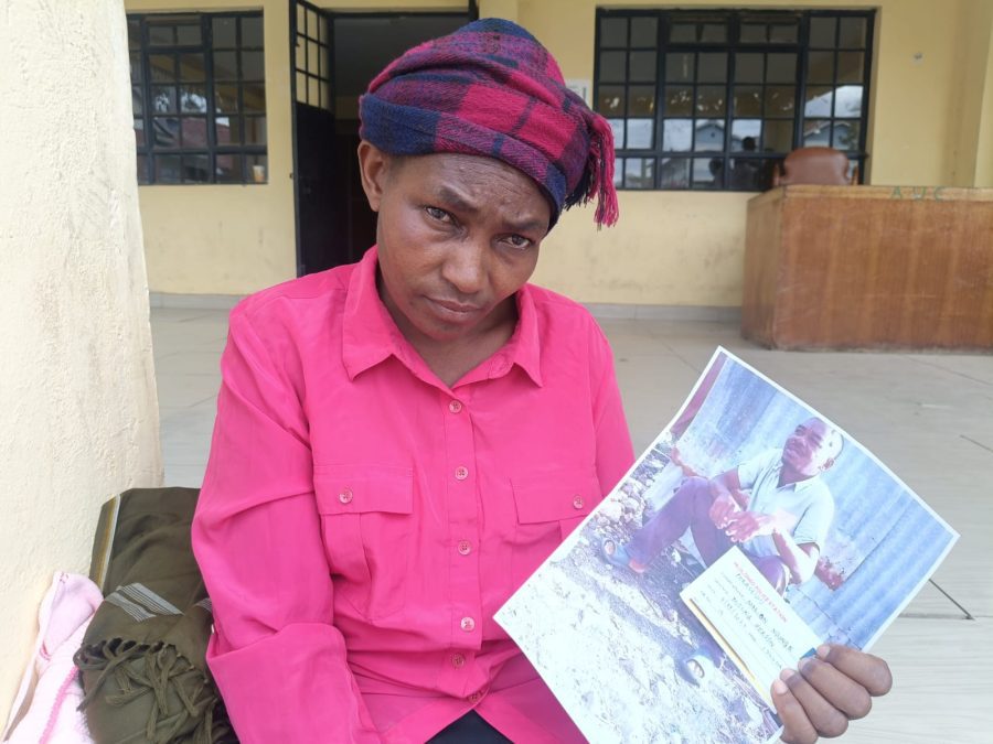 Marion Ndunge holds  a portrait of her missing husband Nicholas Alex Otieno. PHOTO /Christine Musa