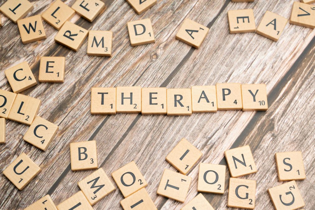 The word therapy is spelled out in Scrabble letters to advocate for therapy