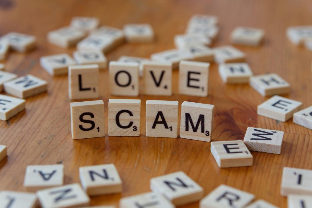Scrabble tiles spell out love scam on table