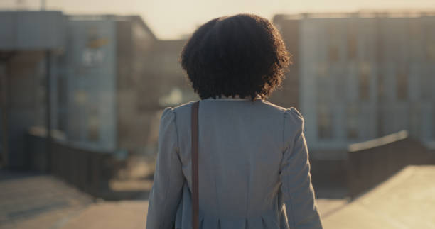 A woman seen from behind, walking. PHOTO/Pexels