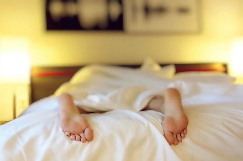A sleeper’s legs visible from beneath a duvet. Image used for illustration. PHOTO/Pexels