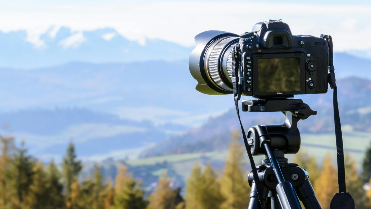 An image of a camera placed on an hill top focusing on a subject. PHOTO/Pexels