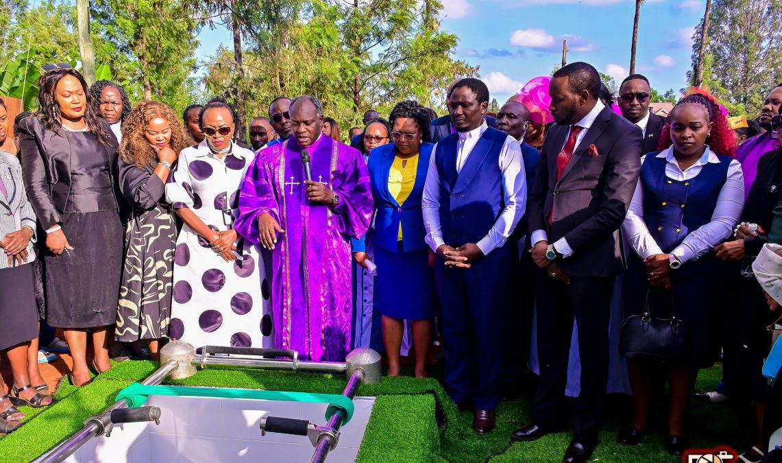 Evangelist Wa Ngujiri stands next to Bishop Wanderi during Betty Bayo's burial. PHOTO/https://www.facebook.com/KaranguMurayaMc
