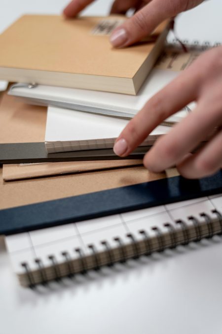 Someone handling books in an office. PHOTO/Pexels