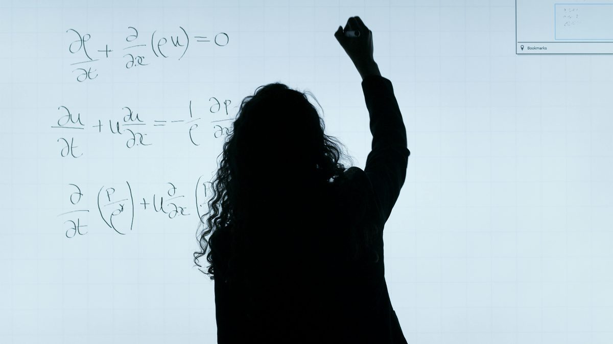 A silhouetted figure of a teacher writing on a whiteboard. Image used for illustration purposes. PHOTO/Pexels