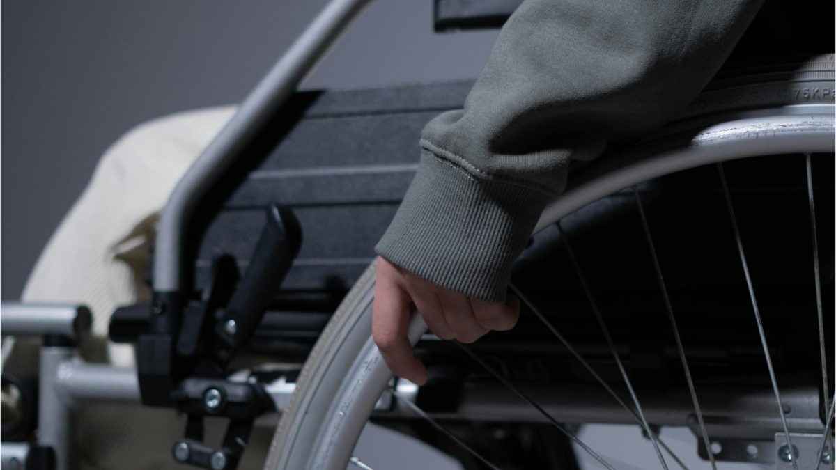 Person in Gray Sweater Sitting on Wheelchair
