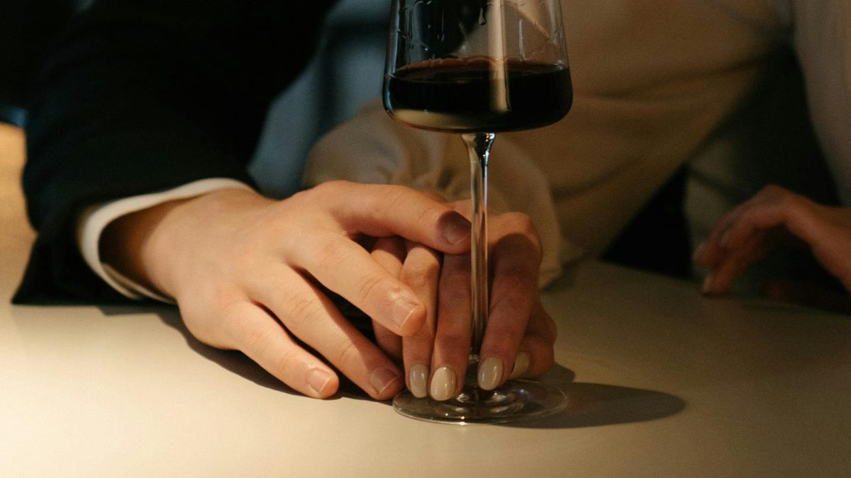 Two people holding a glass. Image used for illustration purposes. PHOTO/Pexels