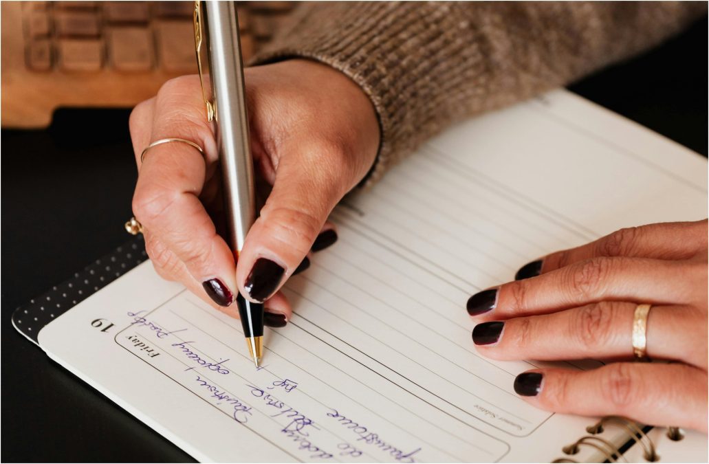 Crop woman writing notes in notebook,image used for illustration purposes in this article. PHOTO/Pexels