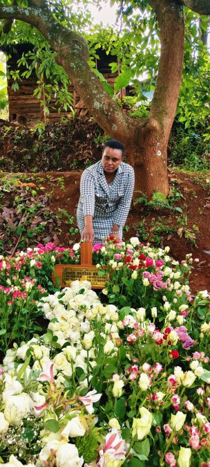 Njeri Wa Muiagi Njoroge poses next to her mum's grave. PHOTO/https://web.facebook.com/njeriwamuigainjoroge