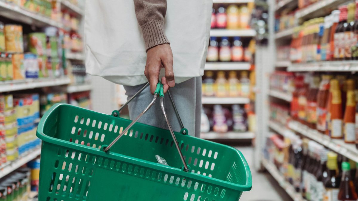 A shopper holding a shopping basket.