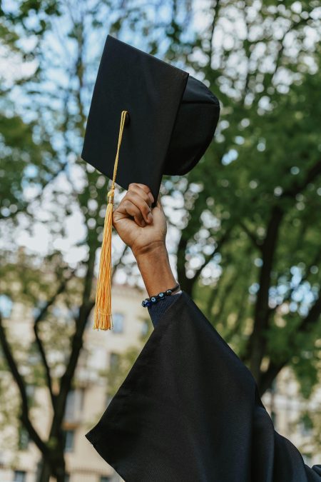 A person holding a black graduation hat. Image used for illustration purposes. PHOTO/Pexels