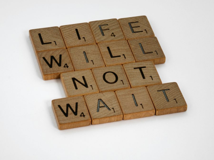 A well-designed graphic with letters well arranged to form "LIfe will not wait". PHOTO/Pexels