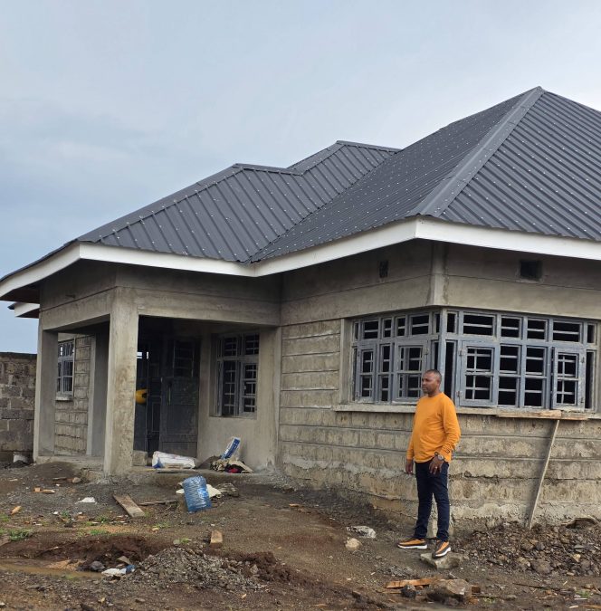 Bishop Kiengei standing next to the house that is under construction. PHOTO/ https://www.facebook.com/muthee.wawatoria