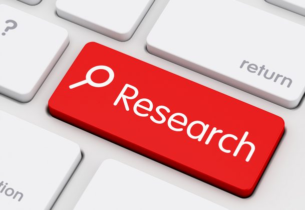 A close up of a computer keyboard featuring a bold red key labelled Research with a magnifying glass icon. PHOTO/Pexels