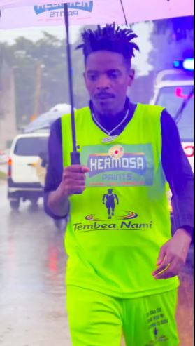 Eric Omondi braves heavy rain on day 3 of his walk from Nairobi to Busia. PHOTO/A screengrab image by K24 Digital from https://www.facebook.com/profile.php?id=100044317755329