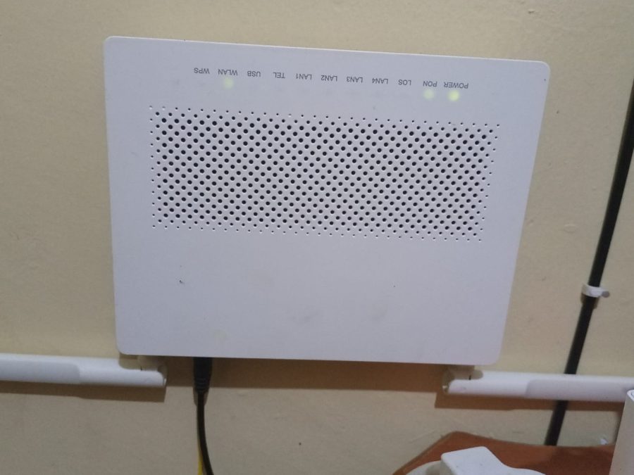 A WiFi router mounted on a wall with indicator lights showing power and network activity, a device that distributes wireless internet signals to connected devices inside a house. PHOTO/David Nthua