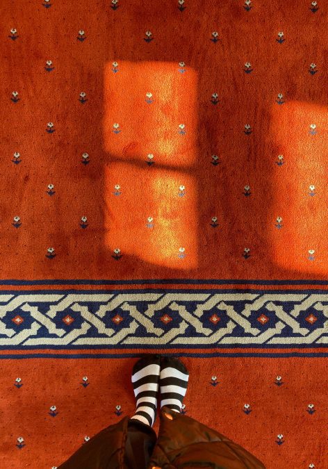 A person standing on a carpeted floor. PHOTO/Pexels