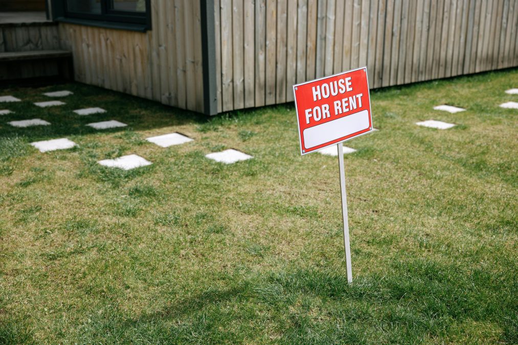 Red and White Sign Board on the Lawn Grass
