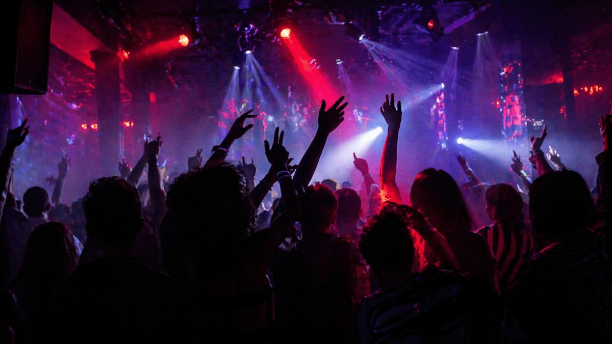 People enjoying themselves in a dark nightclub with colorful lights and faces hidden in silhouette. PHOTO/Photo generated by AI