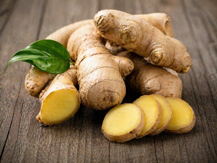 Fresh ginger root with sliced pieces arranged on a rustic wooden table. PHOTO/Photo generated by AI
