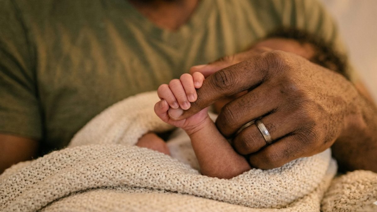 Generated image of a newborn holding a man's index finger. PHOTO/Gemini