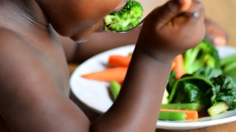 A child eating vegetables.