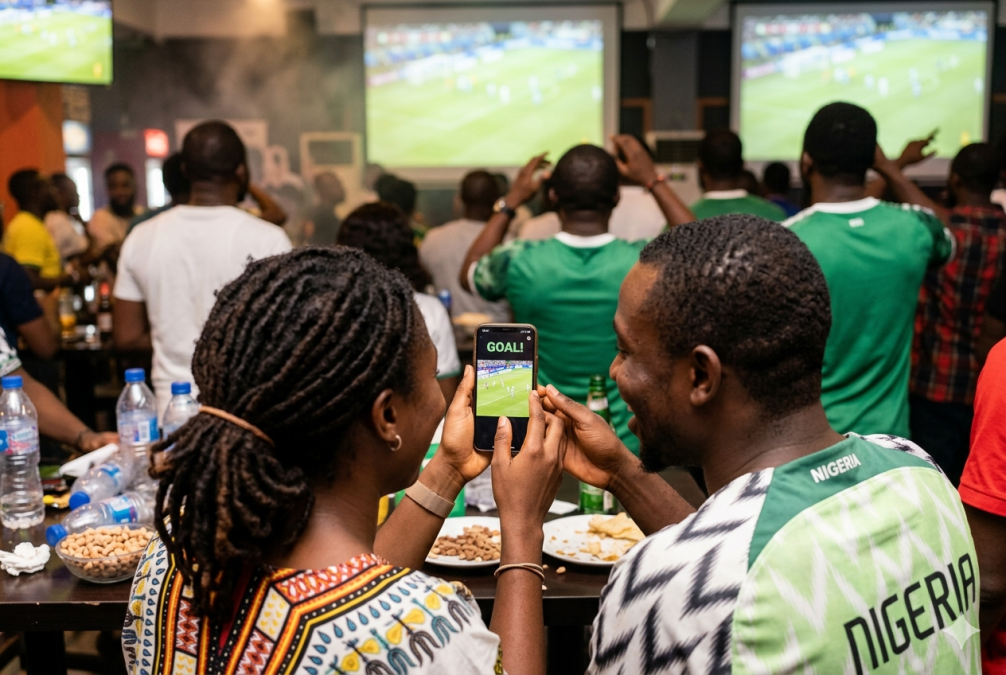 Friends share football joy via smartphone. PHOTO/AI