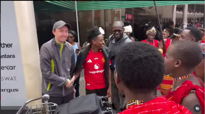 Eric Omondi receiving Manchester United fans’ coach at JKIA. PHOTO/screengrab by K24 Digital from video posted by @trudykitui/Instagram