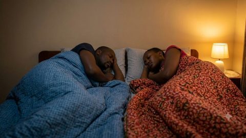A sleeping couple, showing how they use two separate, patterned single blankets to resolve the nightly duvet tug-of-war.