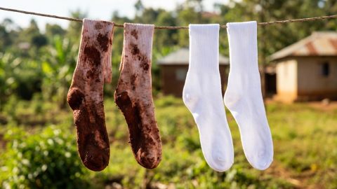 Muddy and clean school socks side-by-side on a clothesline in Kenya.