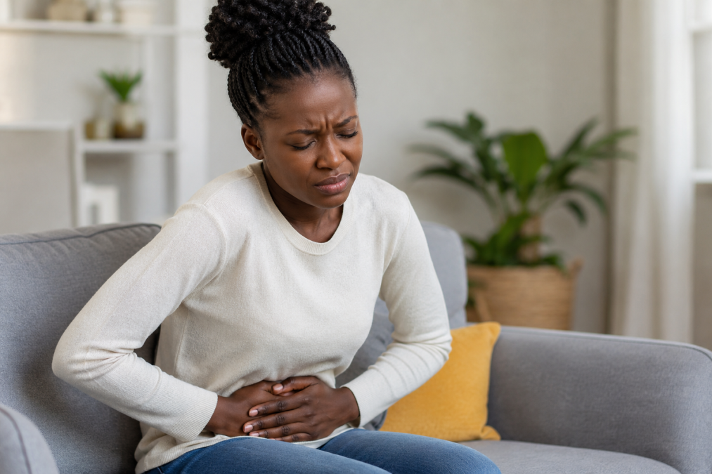 A woman clutches her abdomen in pain.