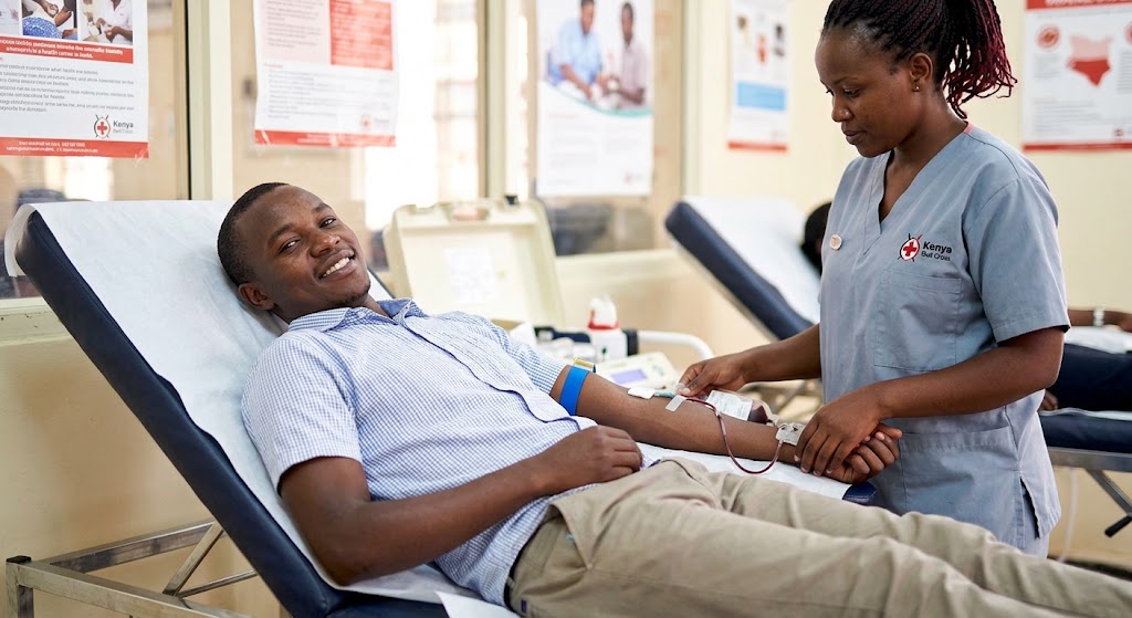 A young man donates blood at a community health center.