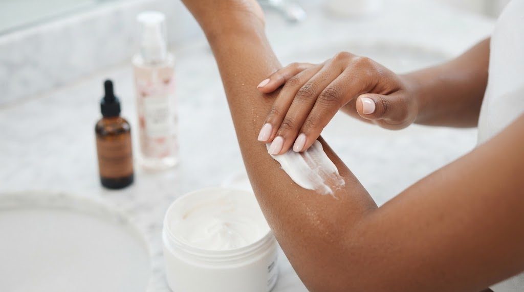 A young woman moisturises her forearm in preparation for scent layering.